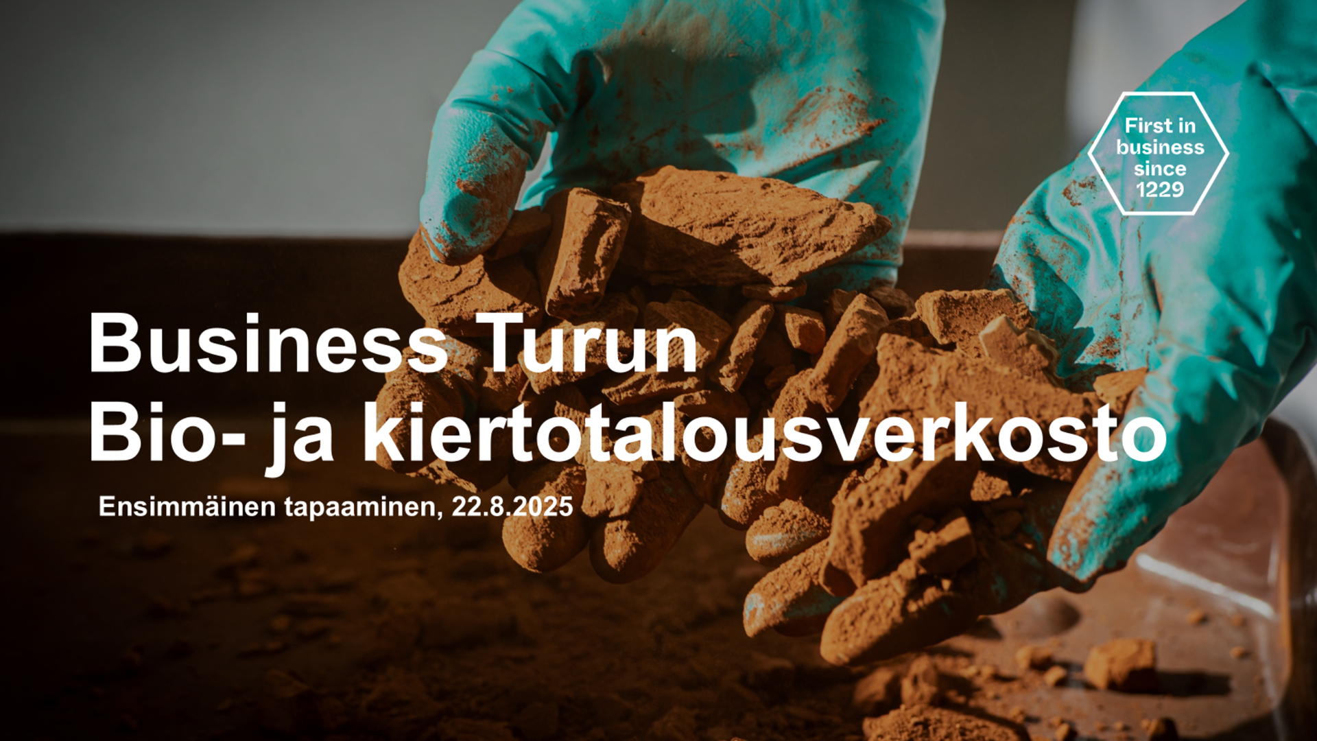 Kädet sinisissä kumihanskoissa esittelevät ruskeaa multaa. Päällä lukee Business Turun Bio- ja kiertotalousverkosto.