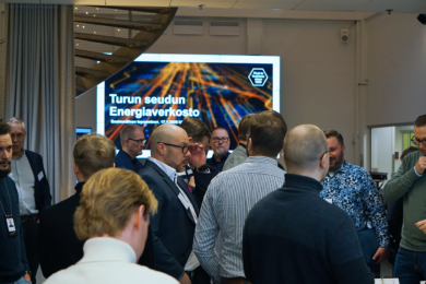 Ihmisiä verkostoitumassa tilassa, takaseinällä on diaesitys jossa lukee Business Turun Energiaverkosto