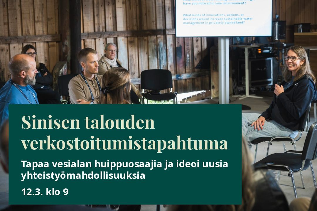 Ryhmä ihmisiä osallistuu keskustelutilaisuuteen puisessa tapahtumatilassa, jossa taustalla näkyy suuri näyttö esitysmateriaalilla. Etualalla on vihreä tapahtumamainos, jossa kerrotaan sinisen talouden verkostoitumistapahtumasta ja sen ajankohdasta.