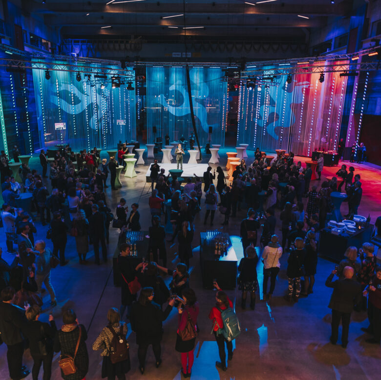 Many people talking to each other in a big event area.